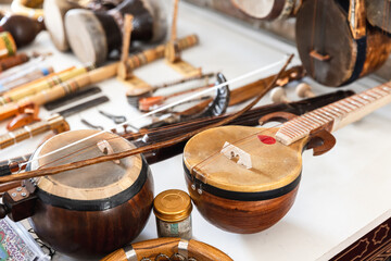 Central Asian stringed musical instruments are put up for sale at a bazaar - obrazy, fototapety, plakaty