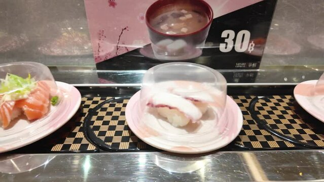 Various type of sushi menu which are served on the conveyor belt at the Japanese food sushi restaurant. 4k footage.