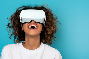 Close-up of a young laughing woman student wearing white augmented virtual reality glasses on a studio blue background with copy space  - Powered by Adobe