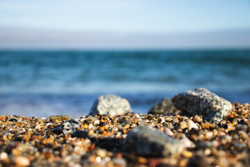 Llevant beach, Barcelona, Spain, on a sunny day, waves and sea, blue sky, sand, pebbles and rocks,...