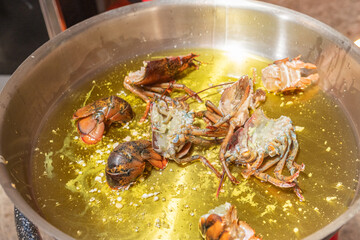 pieces of lobster with oil and garlic to prepare a seafood rice recipe. Paella