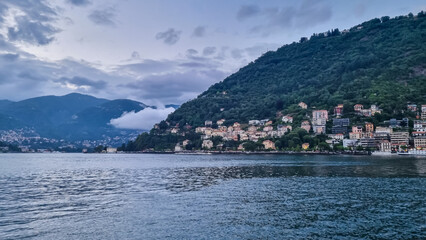 Panoramic view from a boat of city and lake of Como, Lomardy, Italy, Europe. Yachting on alpine mountain lake in the Italian Alps in summer. Living luxury life style, architecture and travel concept - obrazy, fototapety, plakaty