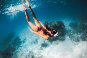 Woman with sporty body snorkeling in blue sea. Swimming underwater in ocean on Oahu