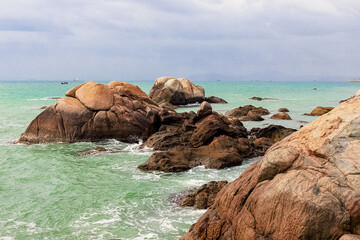 View of large rocks along the shore of the South China Sea. Sky Grottoes Park, Sanya, China