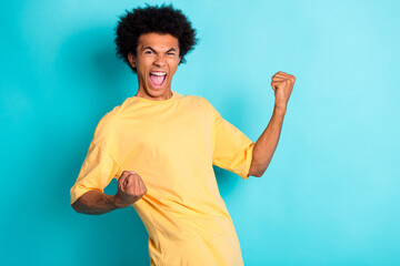 Portrait of overjoyed man with afro hairstyle wear oversize t-shirt clenching fists win betting...