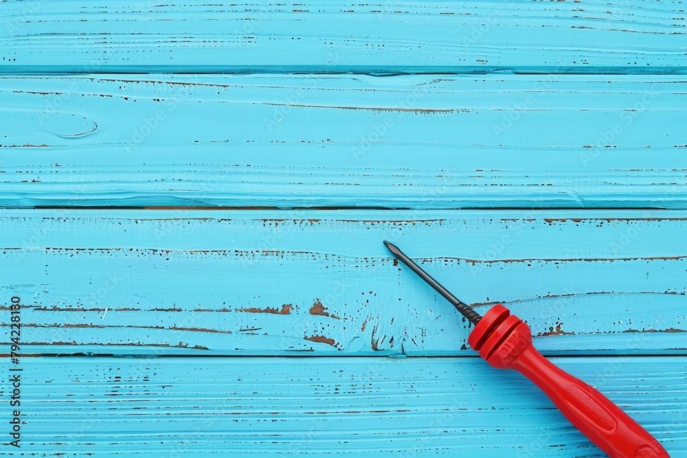 Poster a pair of scissors placed on a blue wooden surface. suitable for crafts or diy projects