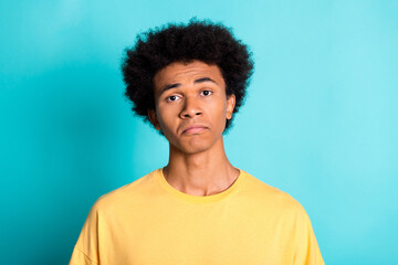 Fototapeta na wymiar Photo of dissatisfied disappointed guy with afro hairdo dressed yellow t-shirt make sad face isolated on turquoise color background