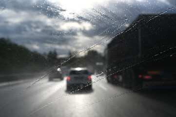 Poor visibility view with the car on the highway with spray and splash rain wetness on the windshield or windscreen from truck. Poor vision.