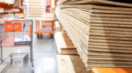 Fototapeta na wymiar Selective focus on corner edge of stacked plywood at a lumberyard hardware store.