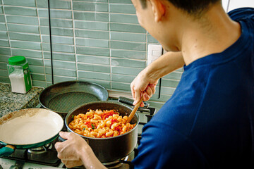 Sunny Pasta Delight: Cooking Penne Pasta with Tomato and Basil on a Bright Day in the Kitchen