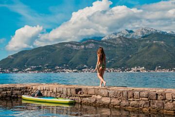young adventurer standing by a calm lake with paddleboard ready for a day of water activities...