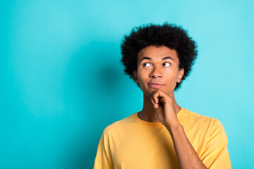 Portrait of intelligent man with afro hairstyle wear oversize t-shirt thoughtfylly look empty space isolated on teal color background