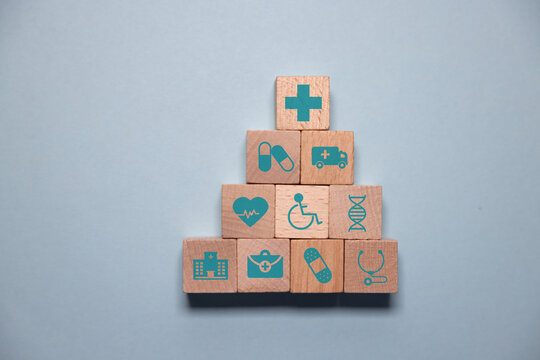 Human hand point cube wood with icons, education, health, housing, gender, basic human needs concept.
