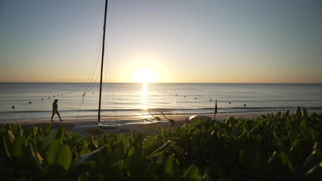View of woman walking on beach at sunrise near Puerto Morelos, Caribbean Coast, Yucatan Peninsula, Mexico, North America