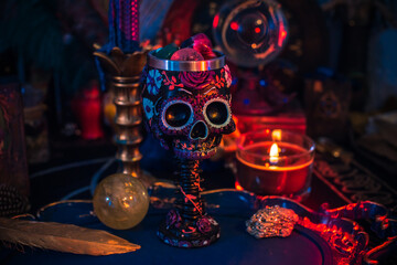 Fototapeta na wymiar Altar cups with a skull with flowers. Santa Muertos or Saint death concept