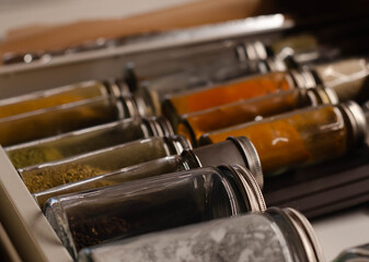 jars of spices lie neatly in order in the drawer