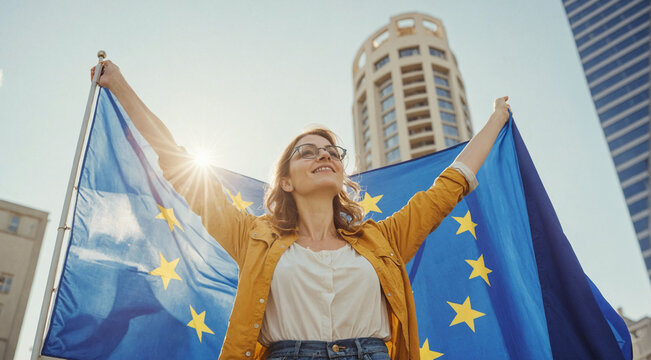 Young woman holding European Union flag against the modern city view, skyscrapers. Patriot, agitation to vote, freedom. Europe day, May 9
