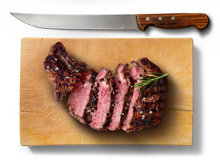 Flavored rib eye beef sliced on wooden cutting board with knife