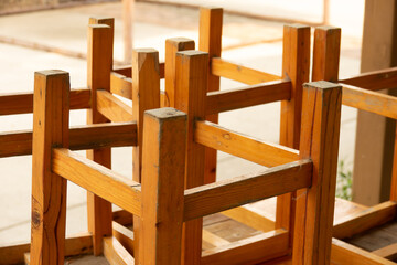 A pile of wooden chairs with their legs removed. The chairs are all different sizes and shapes, but...