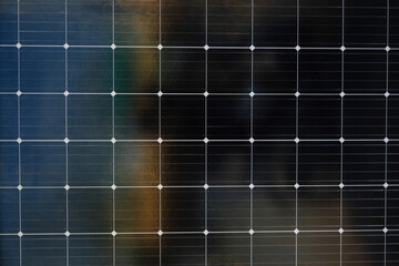 A black and white photo of a solar panel with a grid of white dots. The photo has a moody, somewhat...