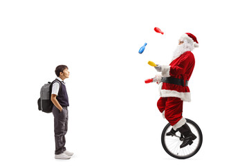 Surprised boy standing and watching santa claus riding a mono cycle and juggling