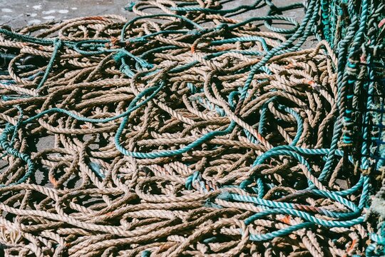 Tangled Fishing Nets and Ropes Strewn Across a Dock on a Sunny Day