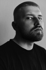 Portraits of a Millennial guy with a short haircut and beard, earrings in his ears