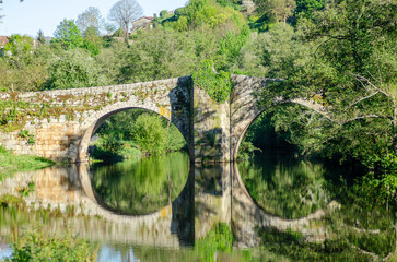 Fototapeta na wymiar Medieval stone bridge over the Arnoia river in the beautiful village of Allariz, Galicia.