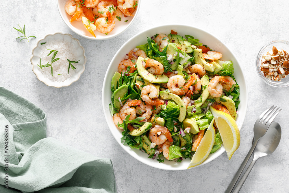 Poster shrimp avocado salad with lettuce and arugula, top view.