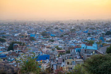 aerial drone shot at dusk sunset showing jodhpur blue city cityscape showing traditional houses in middle of aravalli with colorful densely packed houses