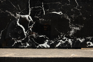 A black and white marble wall with white spots. The wall is very textured and has a lot of detail
