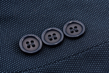 Close-up of black buttons on the sleeve of a man's jacket. Man's jacket. Button