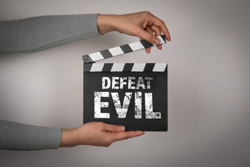 Defeat Evil. Politics Crime Health Concept. Female hands holding movie clapper - 794351760