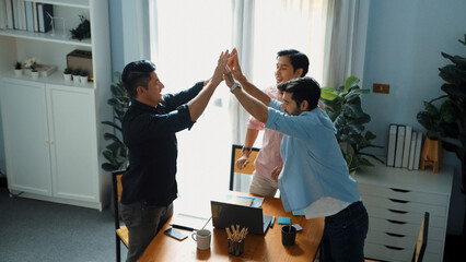 Top view of smart business team looking at laptop while give high five together for celebrate...