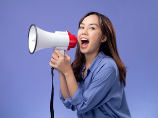 asian woman with megaphone, blue blouse, making an announcement on a vibrant purple background