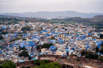 aerial drone shot showing jodhpur blue city cityscape showing traditional houses in middle of aravalli with colorful densely packed houses