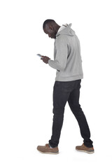 side view of a man walking and looking at smartphone on white background