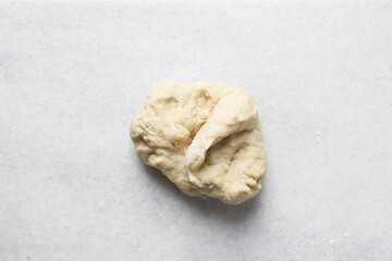 Coco bread dough rising on a a marble countertop, process of making jamaican coco bread