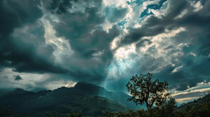 A striking scene featuring a dramatic sky filled with dark, brooding clouds above a rugged mountain landscape with a solitary tree in the foreground.

