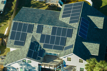 Aerial view of american home roof with blue solar photovoltaic panels for producing clean...