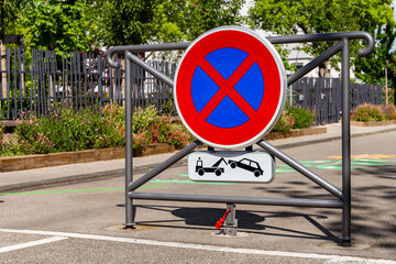 No stopping and no parking sign in a french street. Removal of vehicles. Parking strictly forbidden. No-parking sign with red cross. © Pi-R