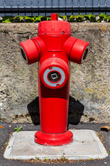 Fire hydrant in french street. Red triple fire hydrant on the street, close up face.