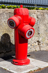 Fire hydrant in french street. Red triple fire hydrant on the street, close up profil.