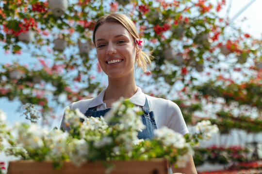 Female florist with flowers in greenhouse