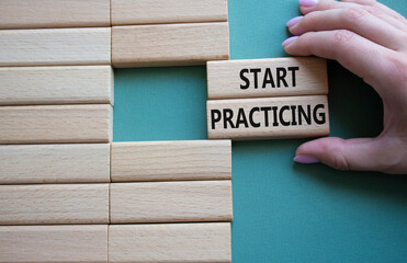 Start Practicing symbol. Concept word Start Practicing on wooden blocks. Beautiful grey green...