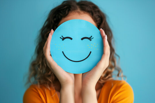 woman holding a happy blue smile face paper cut positive thinking, mental health assessment , world mental health day concept, blue background