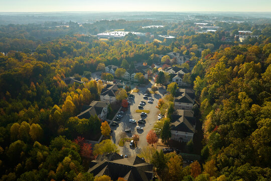 View from above of apartment residential condos between yellow fall trees in suburban area in South Carolina. American homes as example of real estate development in US suburbs