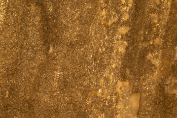 A brown surface with a lot of dust on it. The dust is scattered all over the surface, giving it a rough and aged appearance