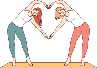 Paired yoga of two women doing aerobics or pilates standing on sports mat and making heart sign from hands. Attractive girls are interested in fitness and pilates to avoid excess weight