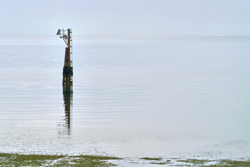 Marine Navigation Aid near Shore. A fixed Navigation Aid with an attached weather sensor marking...